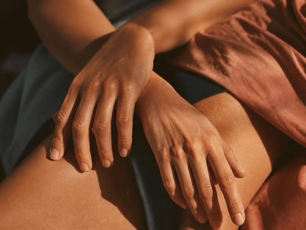 Two hands resting lightly over one another in warm afternoon light